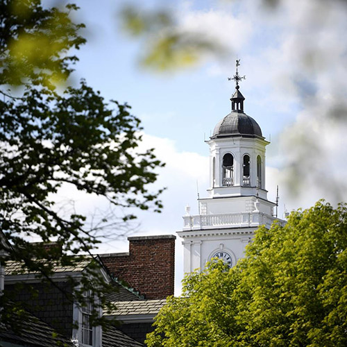 view of Gilman Hall bell tower through trees